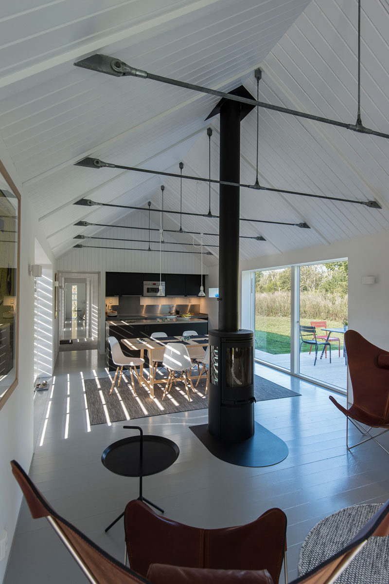 The black kitchen cabinets in this modern barn match the centrally located black fireplace.