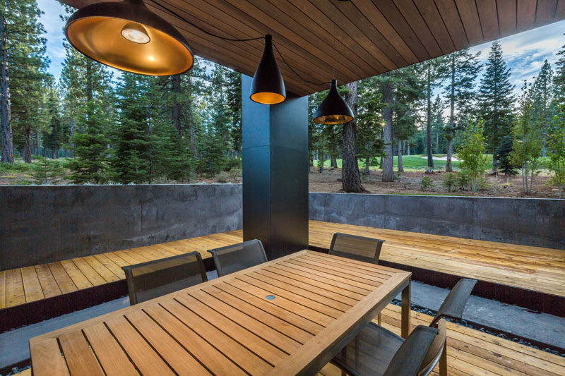 This modern home has a covered deck set up for outdoor dining.