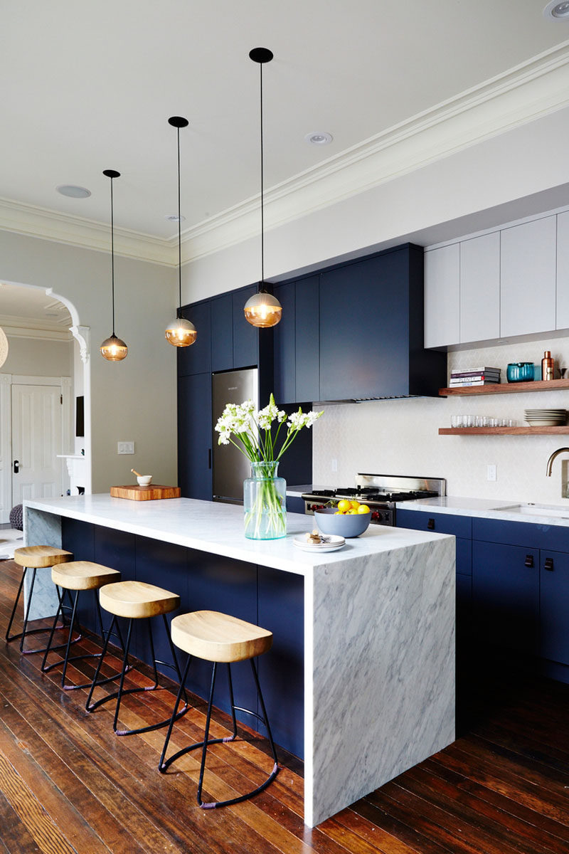 Kitchen Design Ideas - Deep Blue Kitchens // The elements of dark blue are brightened up with the light marble island and backsplash in this modern kitchen.