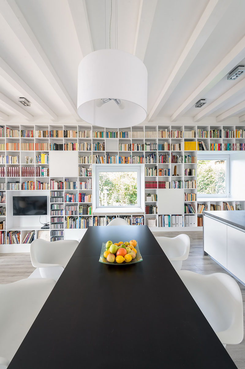 This dining space features a view of the floor-to-ceiling bookshelf and the garden.