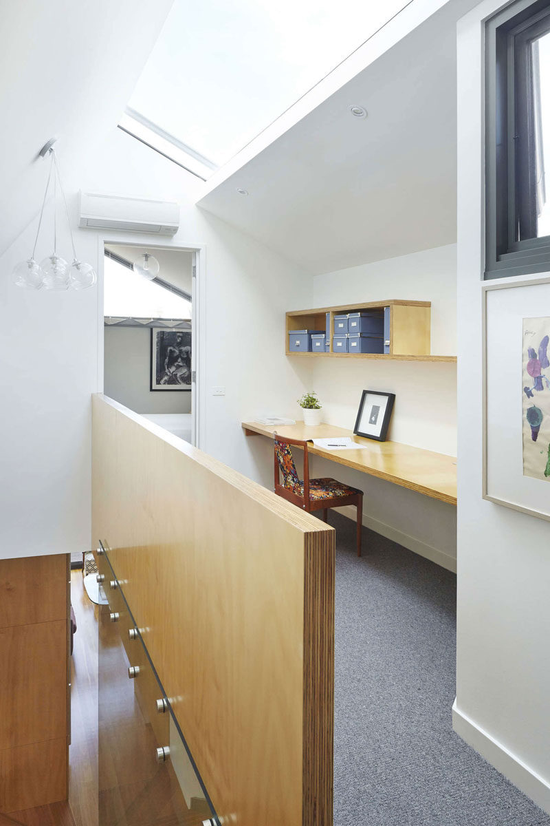 Interior Design Idea - 13 Examples Of Desks In Hallways // A long floating desk with a narrower shelf above it has turned this hallway into a functional workspace, and the space is kept bright by the skylight above.