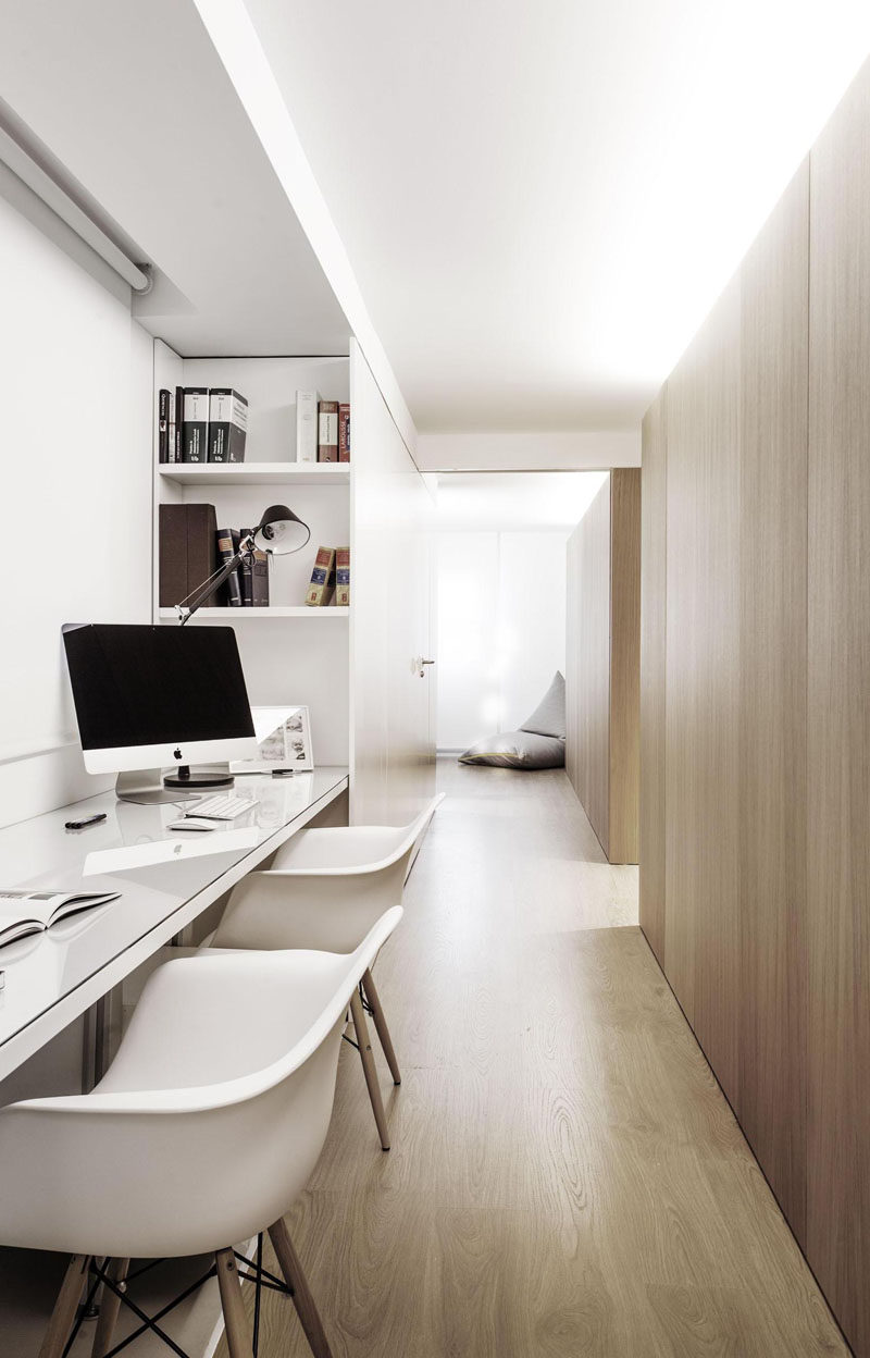 Interior Design Idea - 13 Examples Of Desks In Hallways // Soft lighting from above diffuses throughout the hallway that houses this home office. Shelves built into the sides of the office provide storage and the desk is long enough to provide work spaces for two people.
