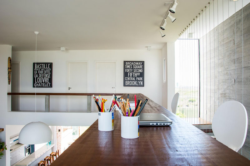 Interior Design Idea - 13 Examples Of Desks In Hallways // On the upper floor of this home, there's a wood railing that acts as an ideal spot to set up shop and get some serious work done, while still being able to be connected to what's going on in the rest of the house.