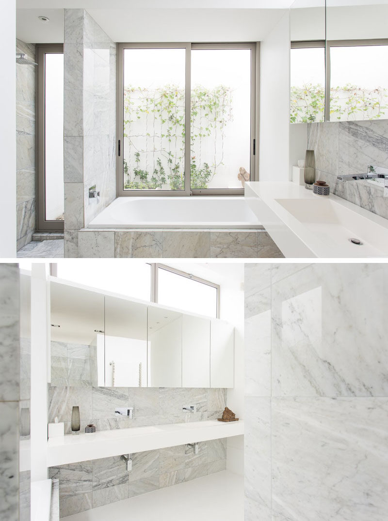 Lots of windows and the light color of the marble used on the walls, floor, and backsplash keep this bathroom feeling bright and airy.