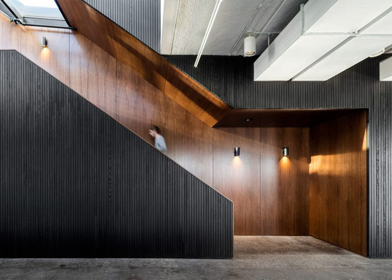 Dark walnut wood treatments line the wall and provide a contrast to the blackened wood on this staircase.