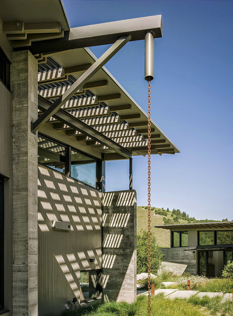 14 Modern Homes That Use Rain Chains To Divert Water // This rain chain has a design reminiscent of an oil pulley, creating an industrial look.