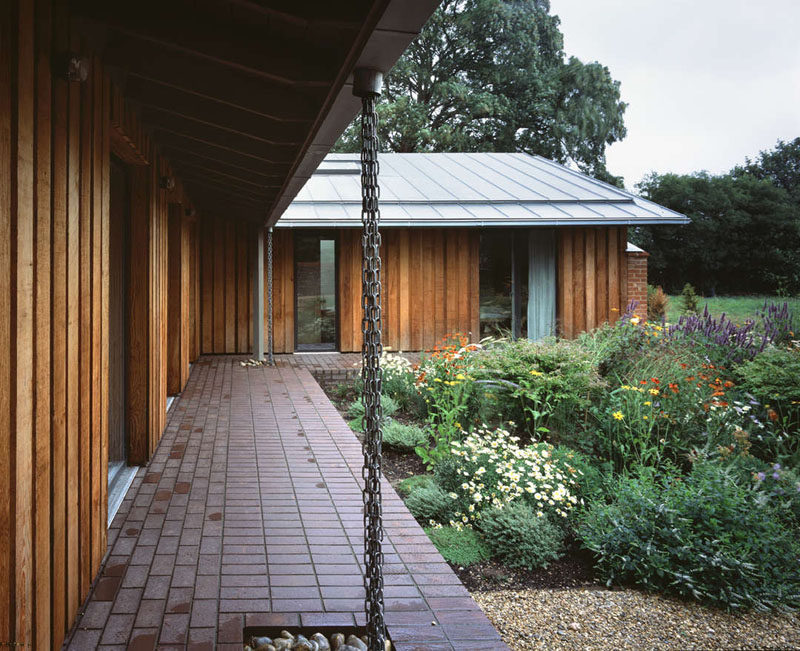 14 Modern Homes That Use Rain Chains To Divert Water // Multiple chains hang in multiple places around the exterior of this home, helping to disperse the water as it falls and prevent it from pooling in one place.