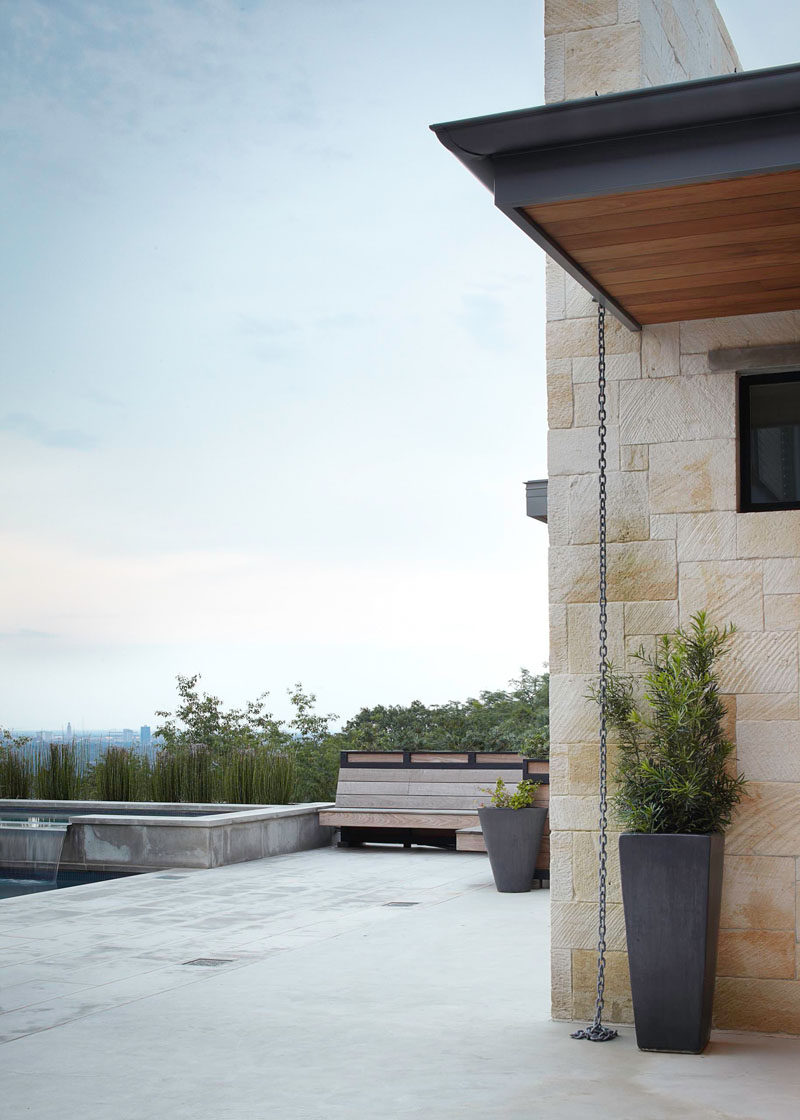 14 Modern Homes That Use Rain Chains To Divert Water // A single chain hangs down from this roof and gathers at the bottom to let the water flow freely away from the house.