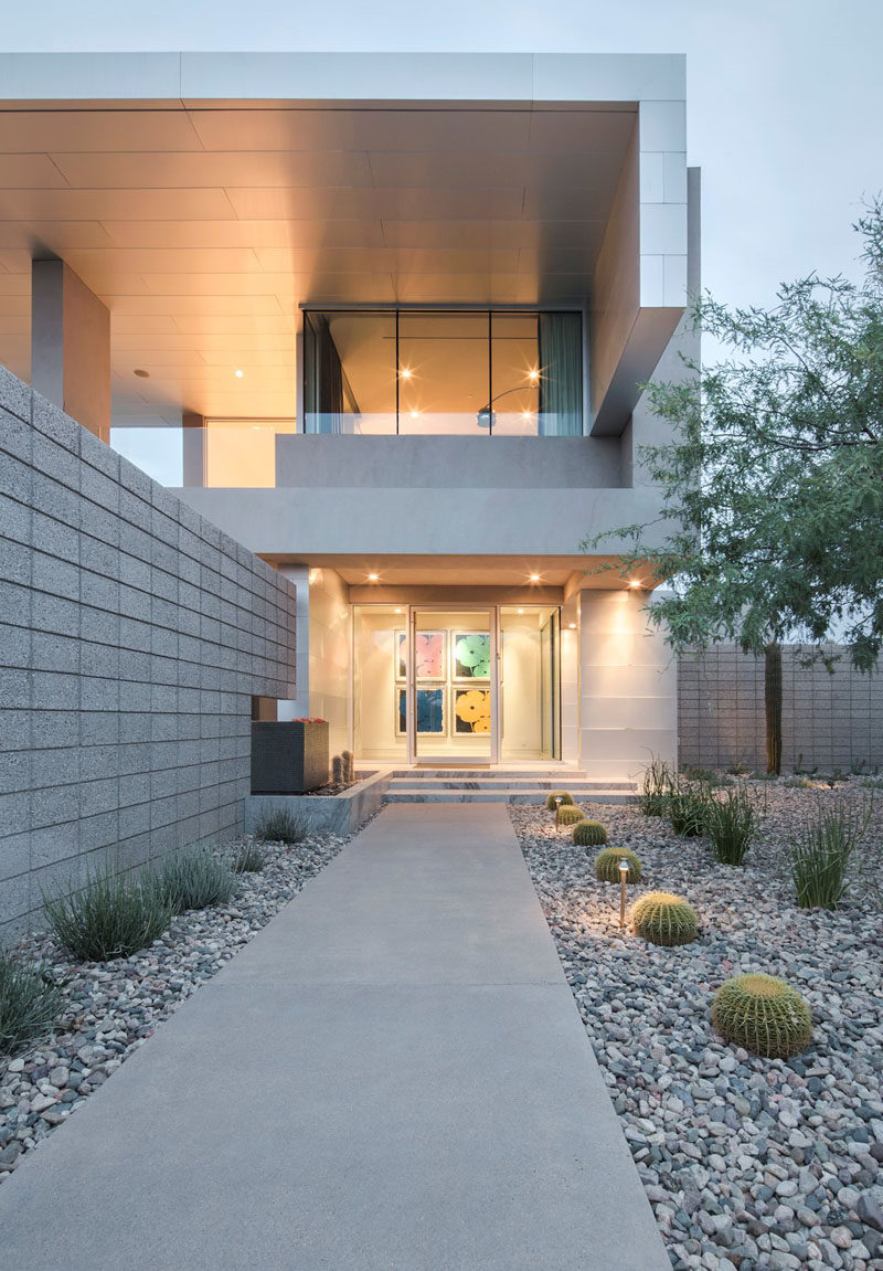 The entrance way and backyard of this home uses rocks and cacti to bring plant life in and watering responsibilities out.  #RockGarden #GardenIdeas #ModernGarden #Landscaping #GardenDesign