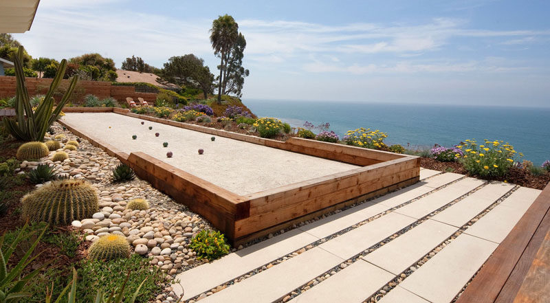 This backyard overlooking the ocean has a rock garden full of cacti and a long strip of gravel designed specifically for playing bocce. #RockGarden #GardenIdeas #ModernGarden #Landscaping #GardenDesign #BocceCourt