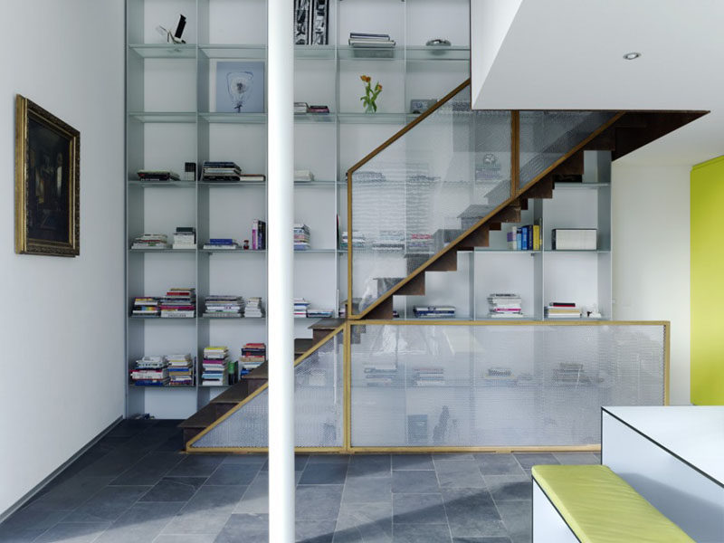 Stairs Design Ideas - 12 Examples Of Staircases With Bookshelves // The floor-to-ceiling bookshelf allows for lots of storage in this open concept home.