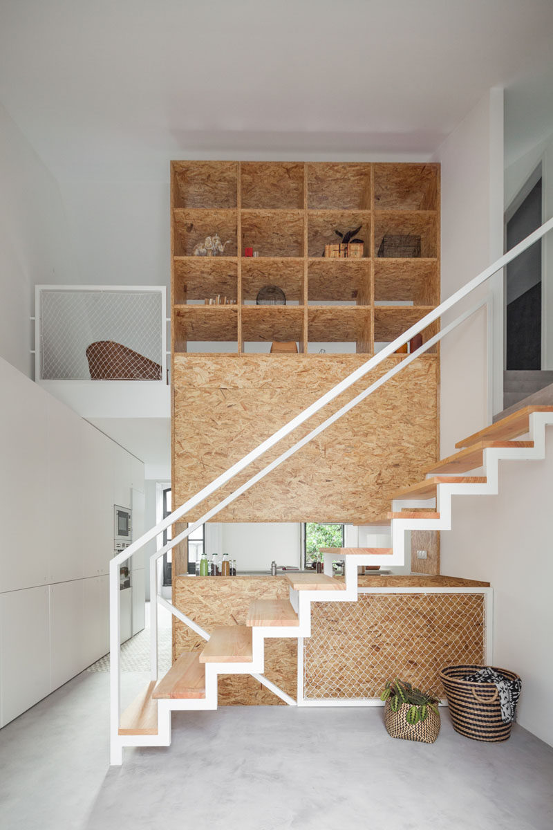 Stairs Design Ideas - 12 Examples Of Staircases With Bookshelves // A wooden wall transforms into an open bookshelf as you climb these stairs.