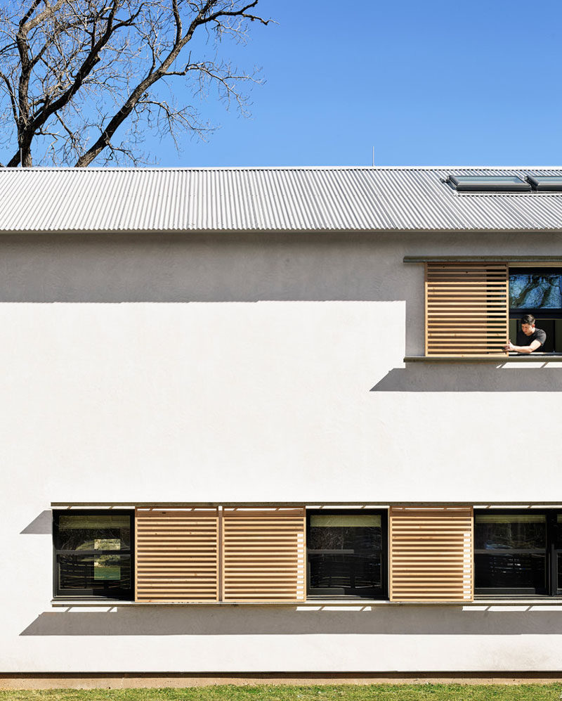 Sliding wood window shutters provide protection from the sun and elements.