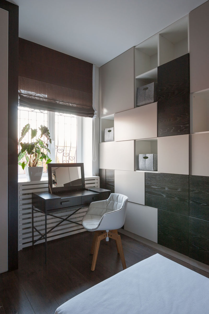 A brown Roman window shade complements the wood found in this small room.