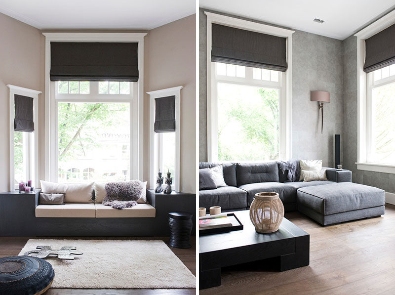 Black roman blinds draw attention to the tall ceilings in this living room.