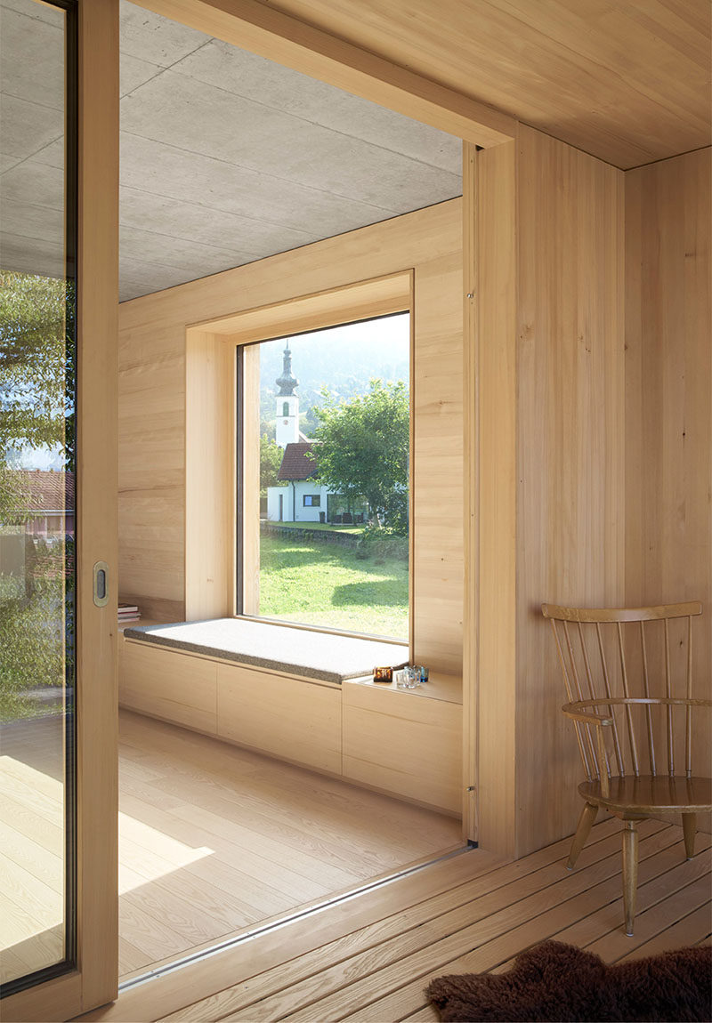 This window has a deep sill and upholstered cushion that extends out to join up with the cabinetry that runs the length of the room.