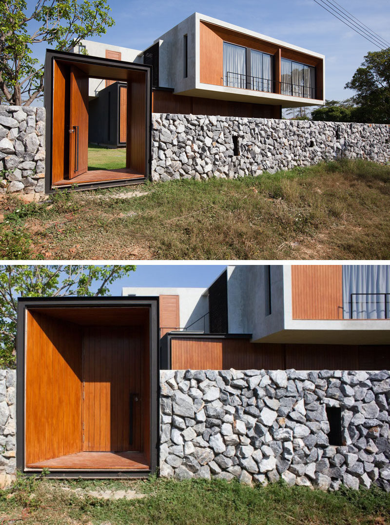 The stone and concrete fence is broken up by a wooden door that provides access to the field behind the house.