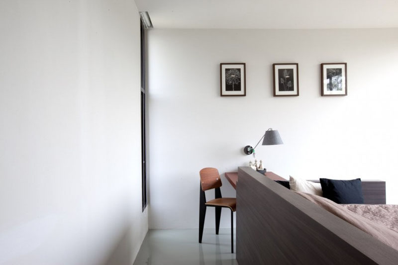 In this bedroom, the bed has been pulled away from the wall to make a walkway to the small home office.