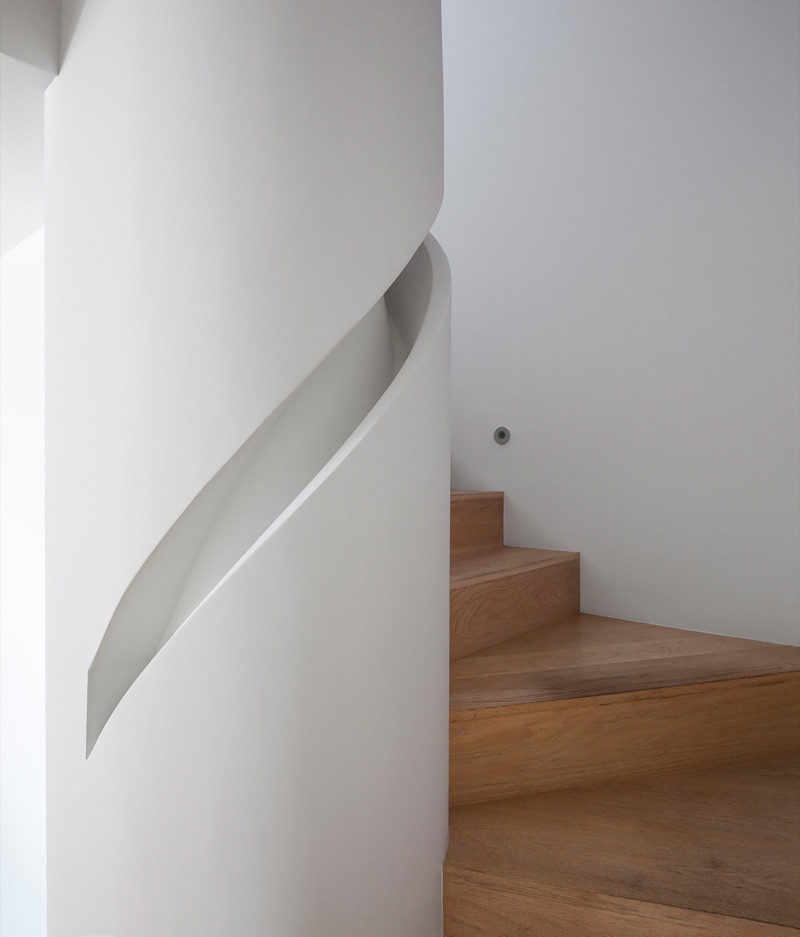 Stair Design Ideas - 9 Examples Of Built-In Handrails // A custom handrail has been built into the column that this staircase wraps around. #BuiltInHandrail #HandrailIdeas #HandrailDesign #StairDesign #Handrails