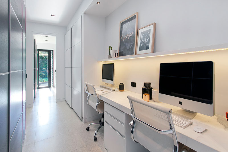 In this hallway, there's a small study area that's been built-in. Hidden lighting underneath a picture rail provides a soft, ambient light for the work area.