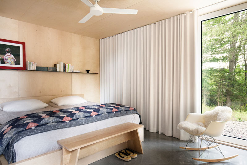 In this bedroom, light wood and soft white curtains help to warm the space up.