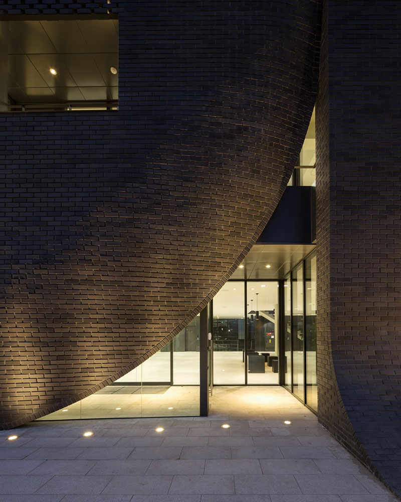 The entrances to this brick building are pulled away like a curtain