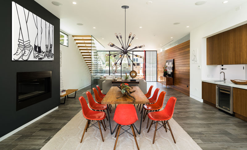 A decorative pendant light anchors this dining table in the room, and the fireplace almost disappears into the black fireplace surround.