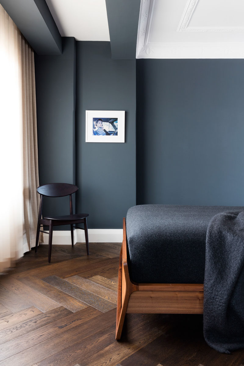 16 Inspirational Pictures Of Herringbone Floors // Dark wood was used on this floor to work with the other dark elements to create a moody feel in this bedroom.