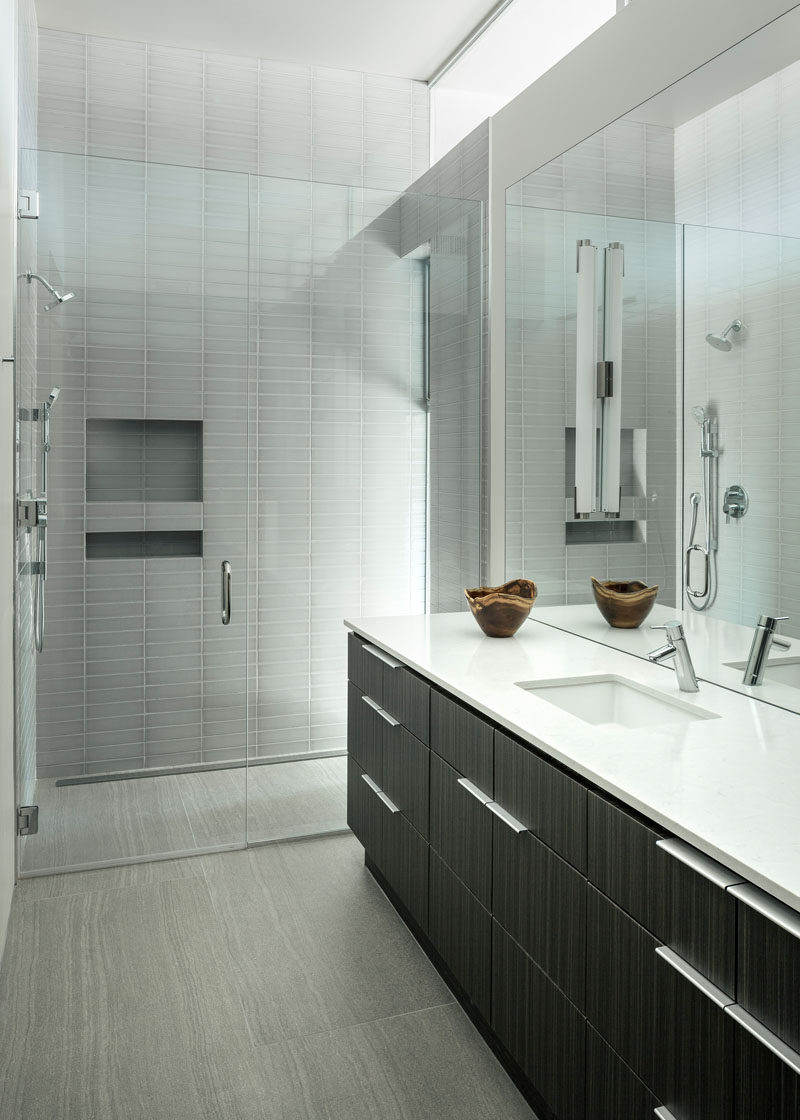 This bathroom has a glass enclosed shower with built-in shelving.