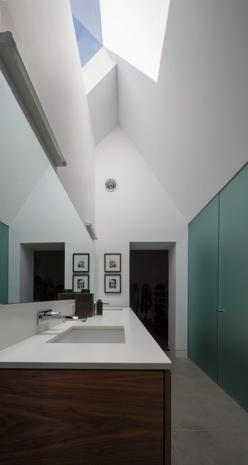 In this new master bathroom, a high gabled ceiling and a skylight draws the eye upward to make the space feel even larger than it is.