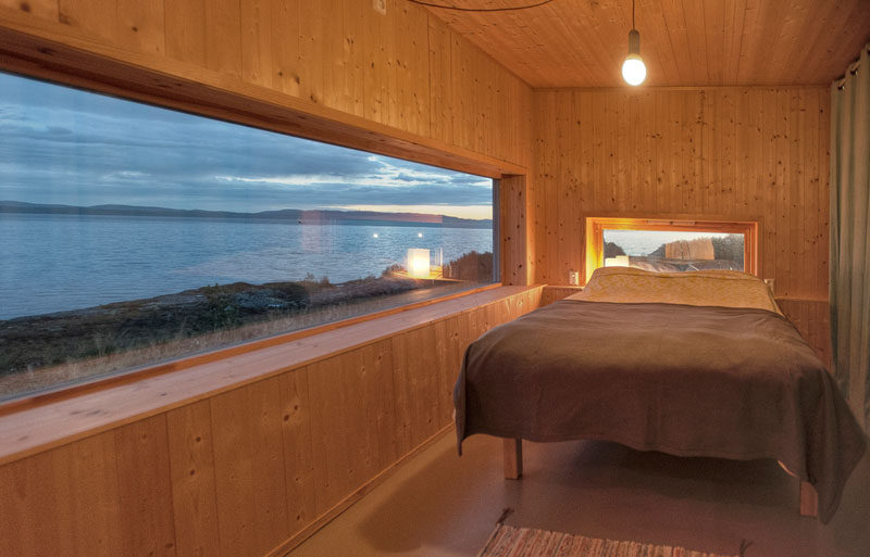 In this small wooden cabin in Norway there are lots of windows that perfectly frame the water views.