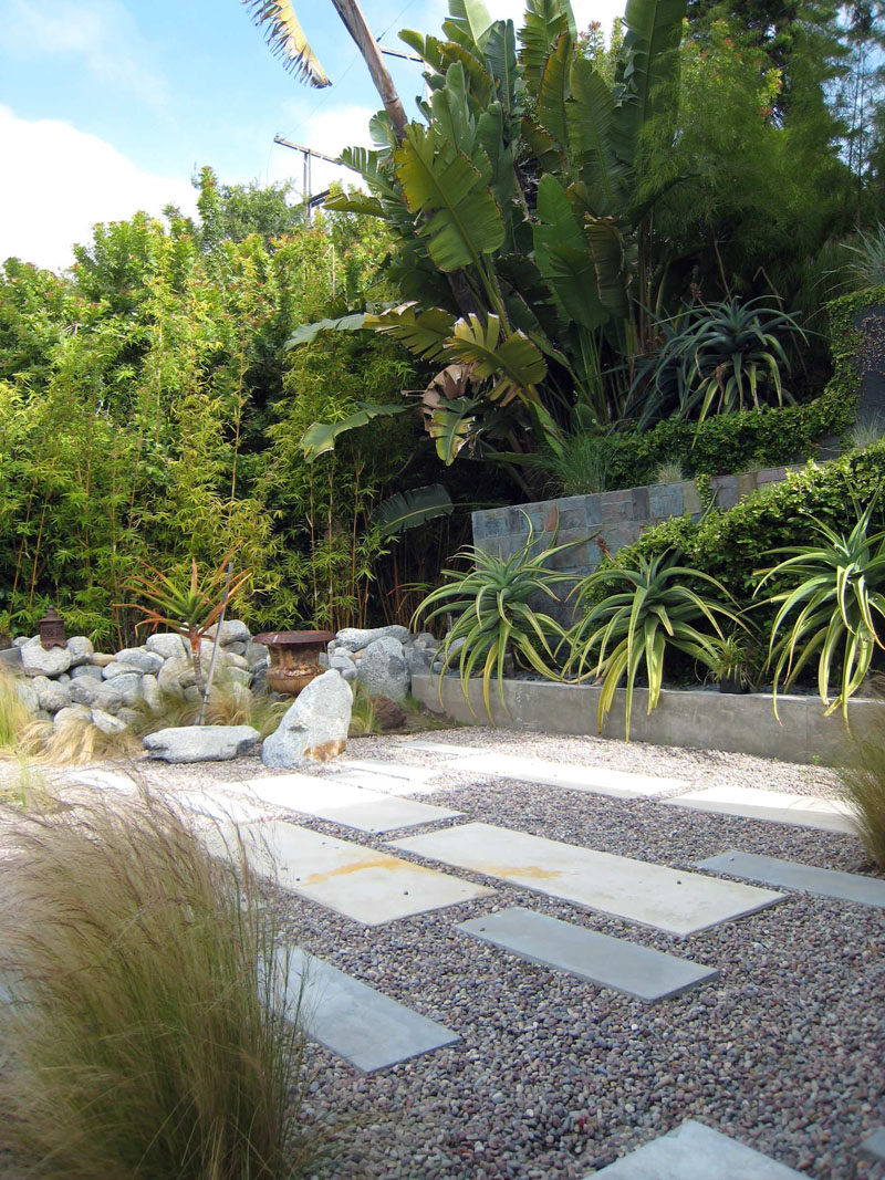 Pavers of various sizes have been placed throughout the yard, and the low maintenance plants and grasses create depth and texture. #RockGarden #GardenIdeas #ModernGarden #Landscaping #GardenDesign