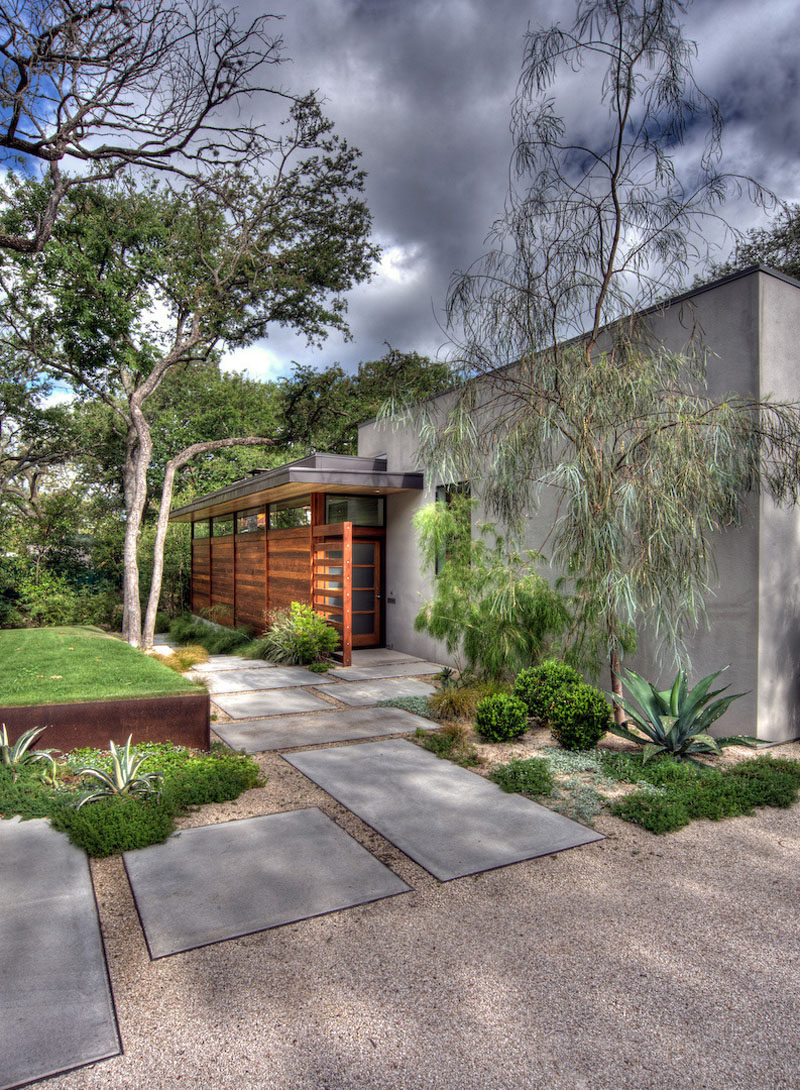 Gravel, drought tolerant plants, and a number of colorful stones are used in both the front and back yards of this home to create an easy to maintain landscape. #RockGarden #GardenIdeas #ModernGarden #Landscaping #GardenDesign