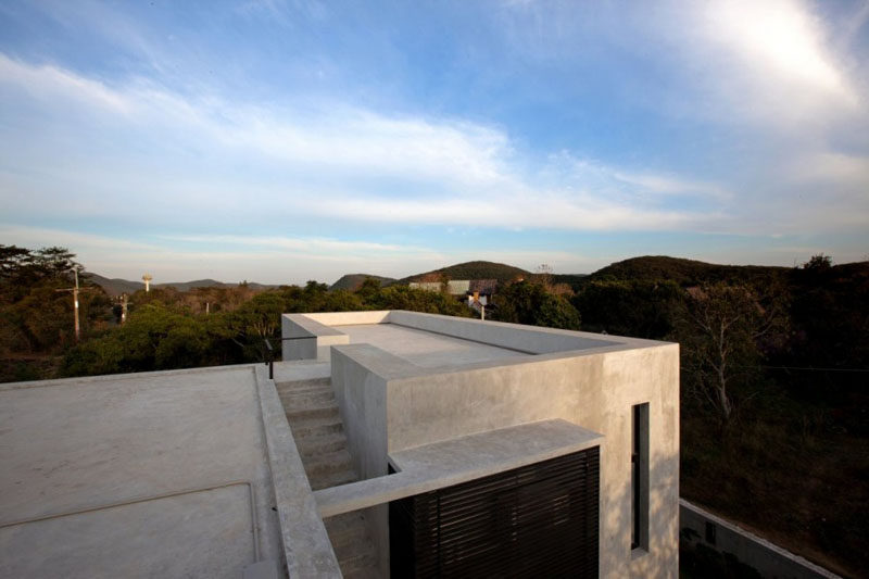 This home in Thailand has a rooftop patio that overlooks the trees.