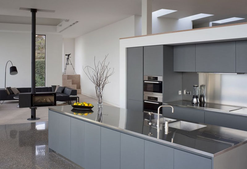 Kitchen Design Idea - Stainless Steel Backsplash // The stainless steel backsplash in this kitchen matches the stainless steel countertops and contrasts the matte grey cabinetry.