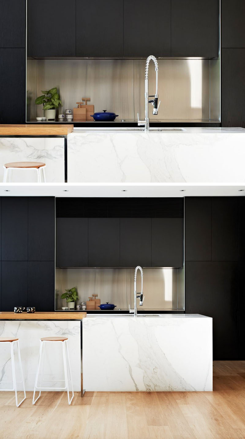 Kitchen Design Idea - Stainless Steel Backsplash // Surrounded by the black cabinets, the stainless steel backsplash in this kitchen creates a contemporary look and makes it easier to clean up when you're done cooking.