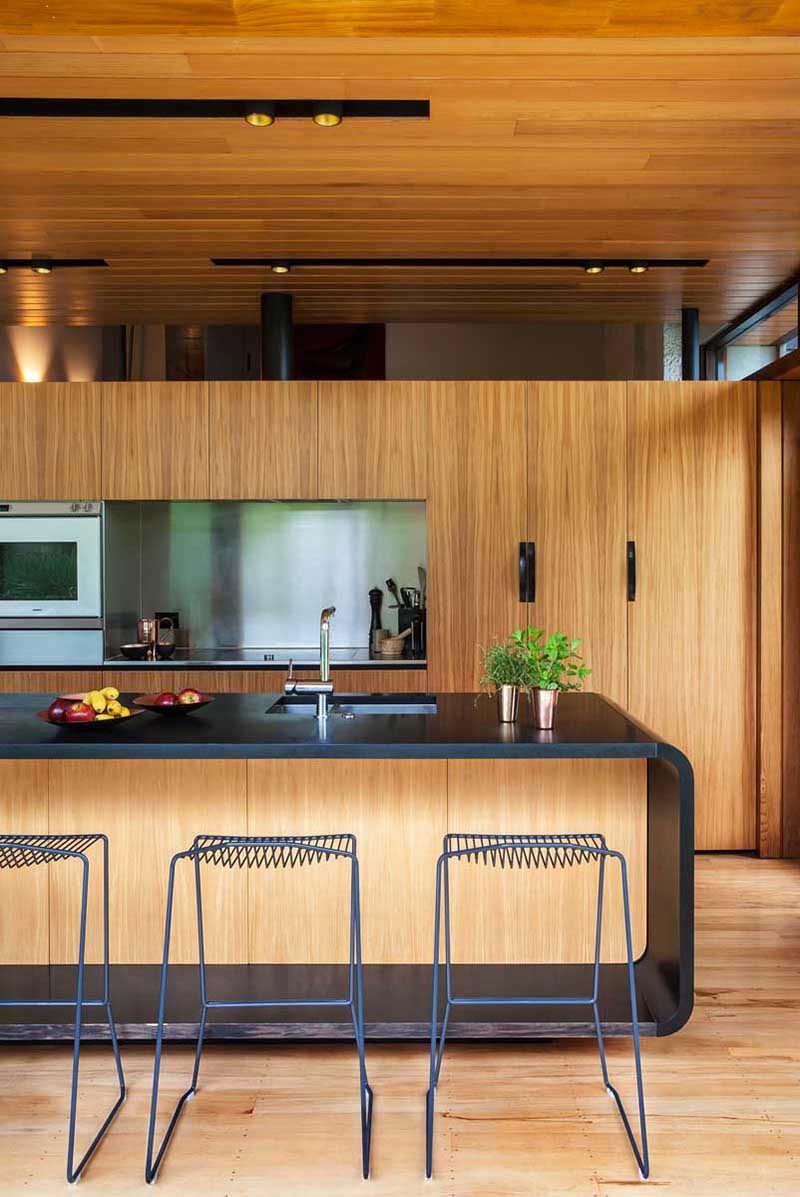 Kitchen Design Idea - Stainless Steel Backsplash // Stainless steel wraps around the cut out spaces in this kitchen to make for easy clean up and to help modernize the wood interior.