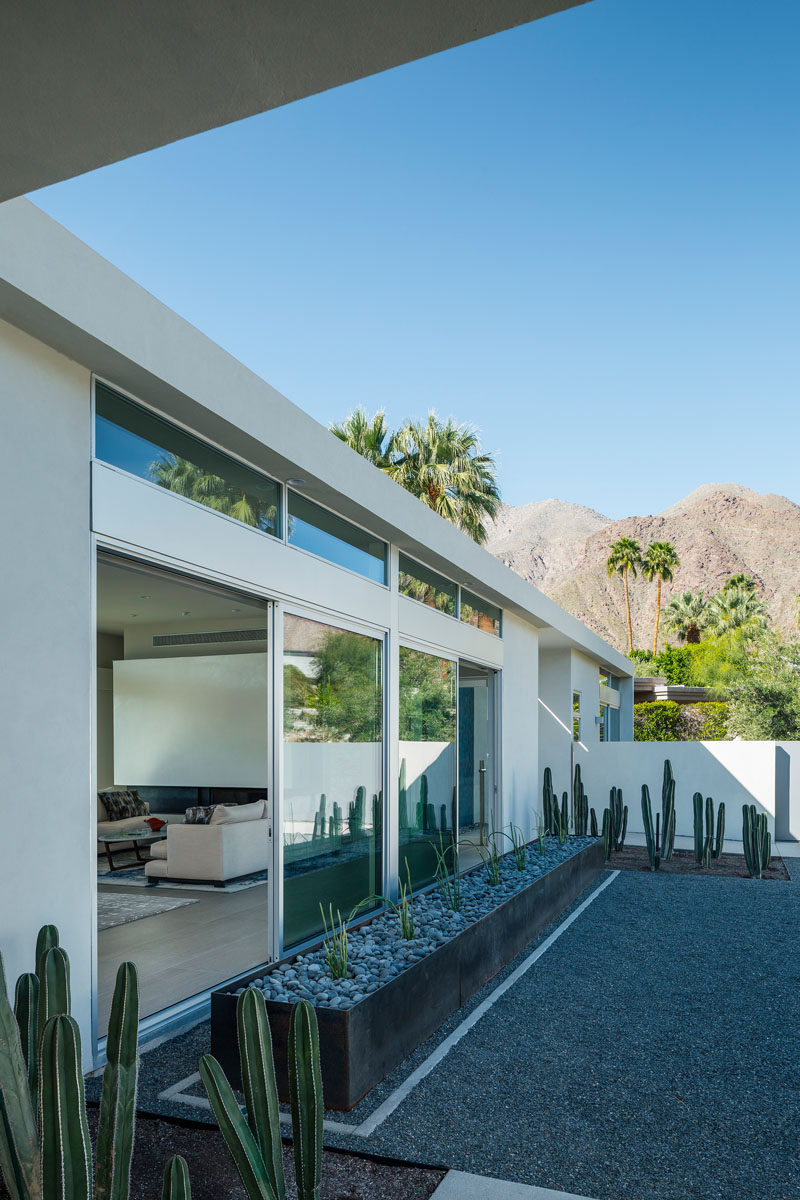 A large steel planter filled with cacti is featured at the front of this Californian home.