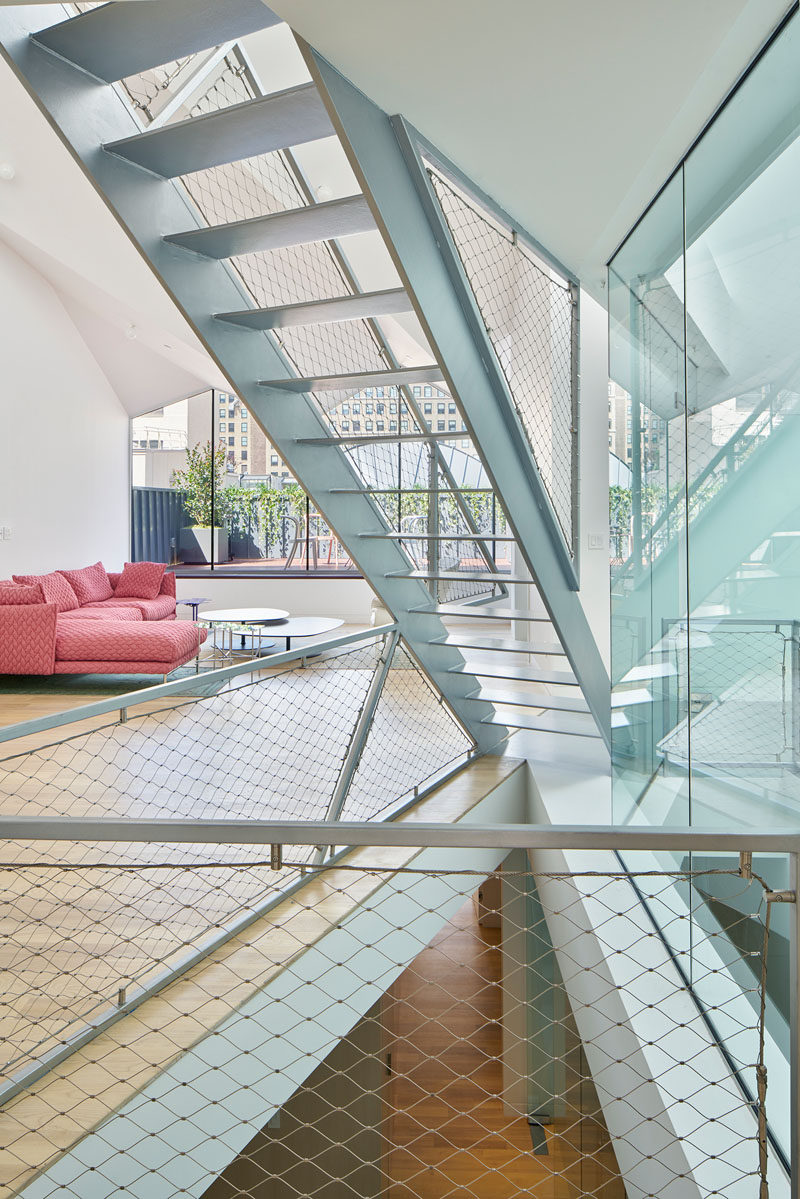 Steel stairs lead you up to the lofted bedroom and ensuite bathroom in this New York penthouse.