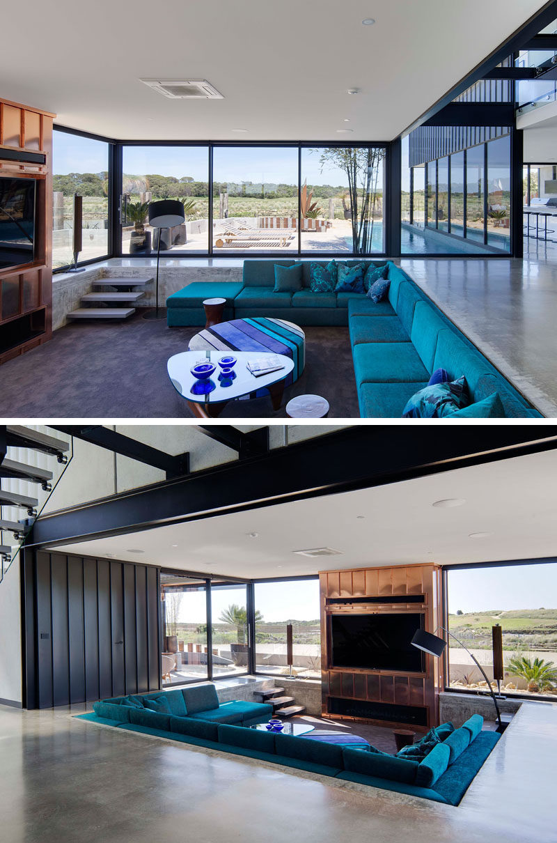 Inside this home, the living room has been sunken down into the floor, making it a unique feature and the copper tv surround draws the eye even more, creating a dramatic look.