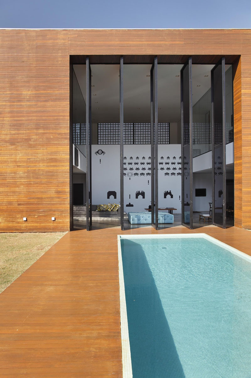  Large oversized vertical doors pivot open to expose the lofty interior of this home.