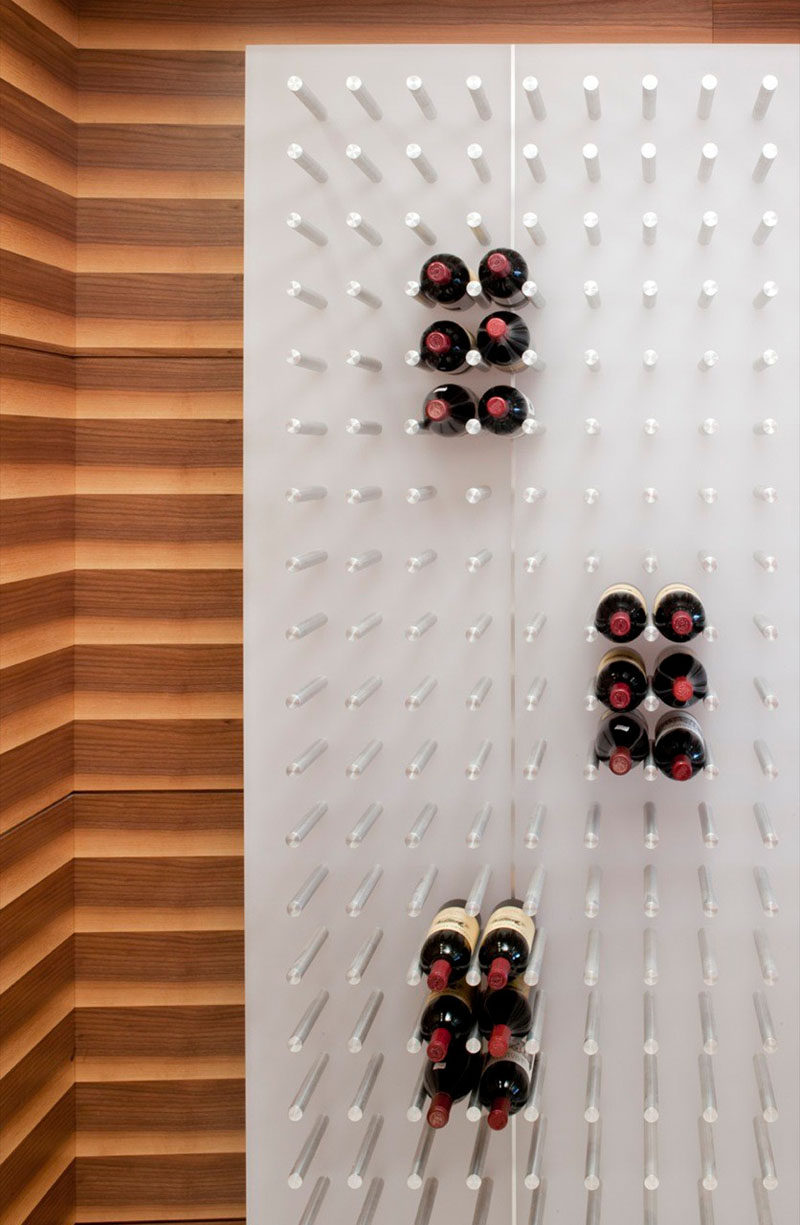 Wine Rack Ideas - Show Off Your Bottles With A Wall Mounted Display // The pegs on this wall can support hundred of bottles of wine for a packed look or just hold a few for a more open and floating look.