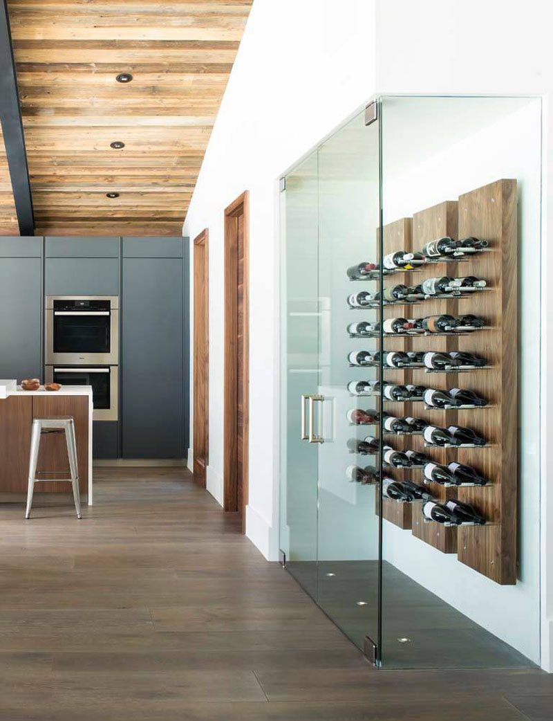 Wine Rack Ideas - Show Off Your Bottles With A Wall Mounted Display // The steel pegs contrast the wood panels and are long enough to fit two bottles of wine on pair of pegs.