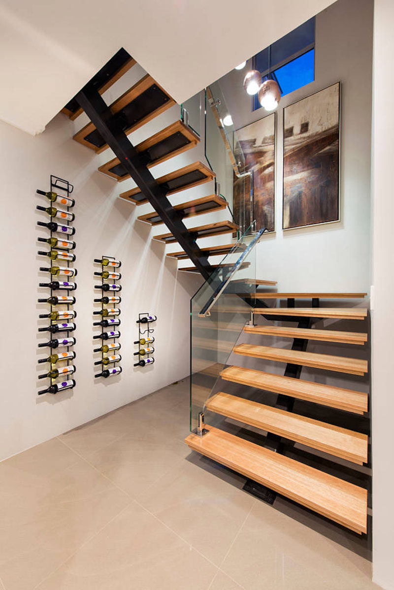 Wine Rack Ideas - Show Off Your Bottles With A Wall Mounted Display // The staggered heights of these three wine racks follow the line of the staircase and create a simple display for all the wine bottles.