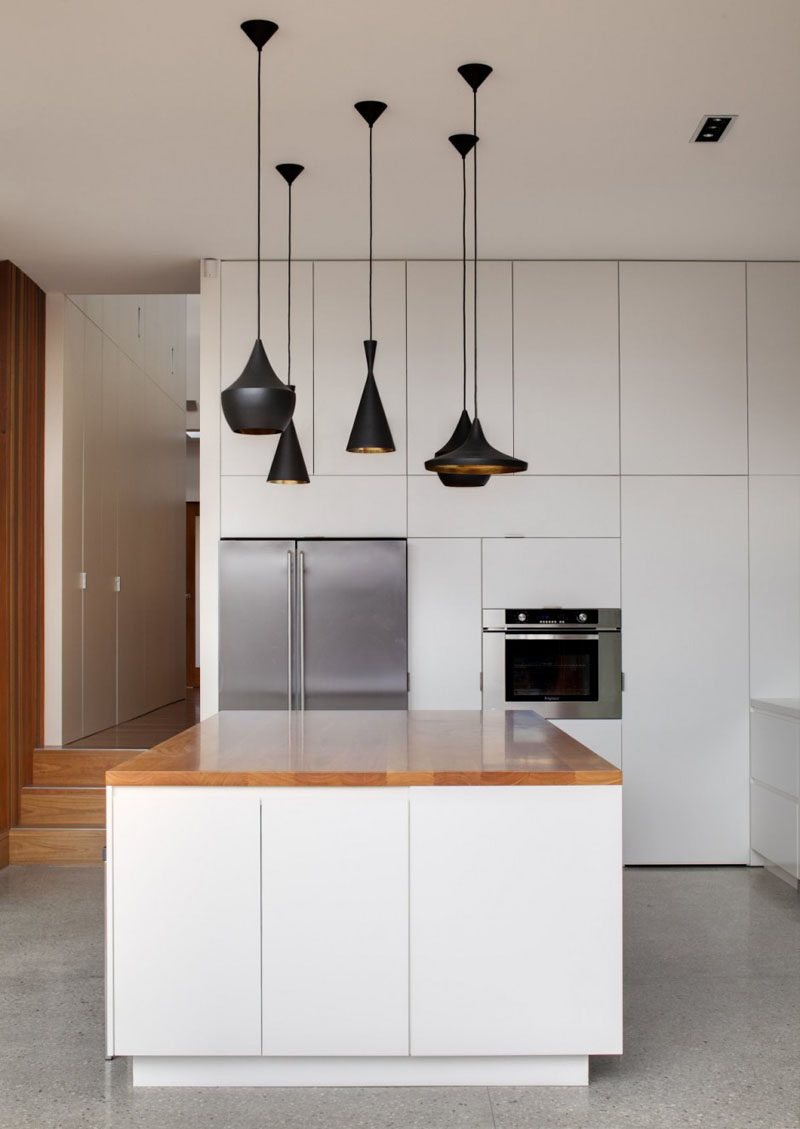 Kitchen Design Ideas - White, Modern and Minimalist Cabinets // White cabinets of different sizes give the walls a geometric look to them and the minimal hardware keeps the cupboards looking smooth.