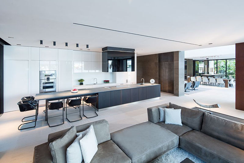 Kitchen Design Ideas - White, Modern and Minimalist Cabinets // The white cabinets in this kitchen contrast the darker elements in the space like the dark island, dark chairs, and dark wall.