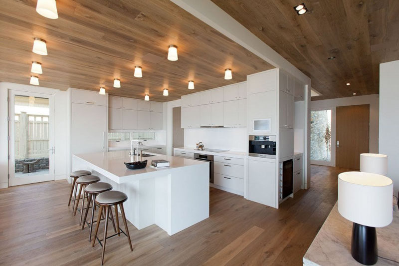 Kitchen Design Ideas - White, Modern and Minimalist Cabinets // This all white kitchen breaks up the wood floor and ceiling to create a more modern looking space.