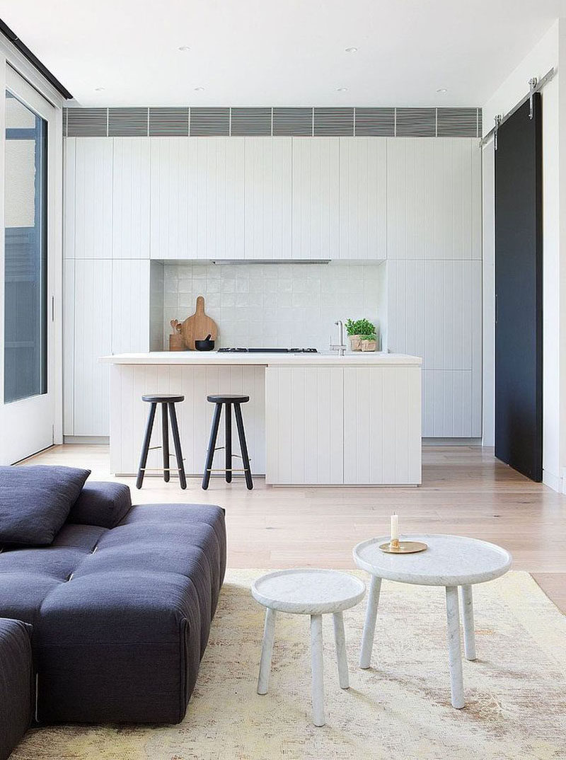 Kitchen Design Ideas - White, Modern and Minimalist Cabinets // A few black details, including the stools, the stove, and the sliding barn door, interrupt the all white cabinetry in this modern kitchen.