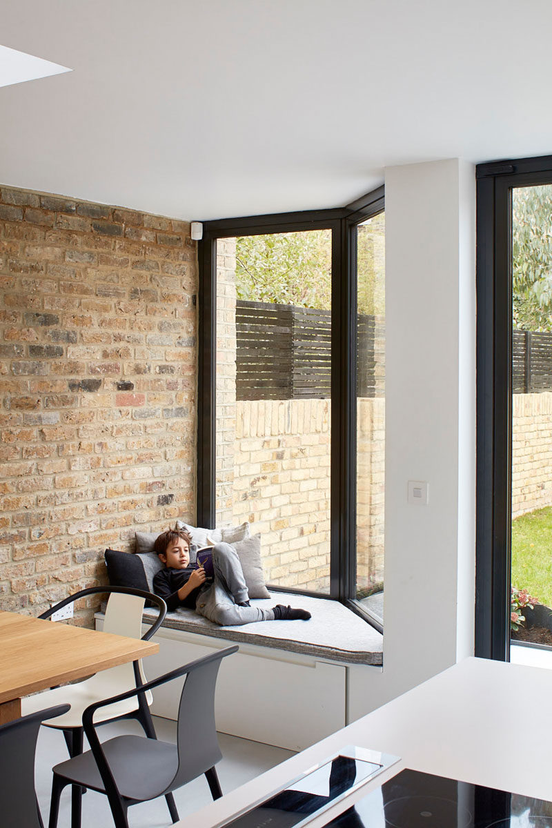 This window has a built-in window seat with an upholstered cushion and storage underneath.