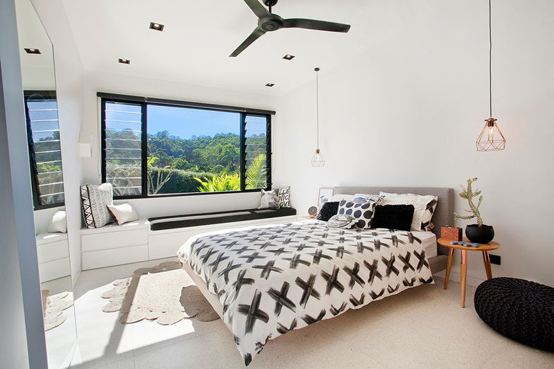 This modern children's bedroom has a built-in window bench with storage, and black elements throughout tie all of the design elements together.